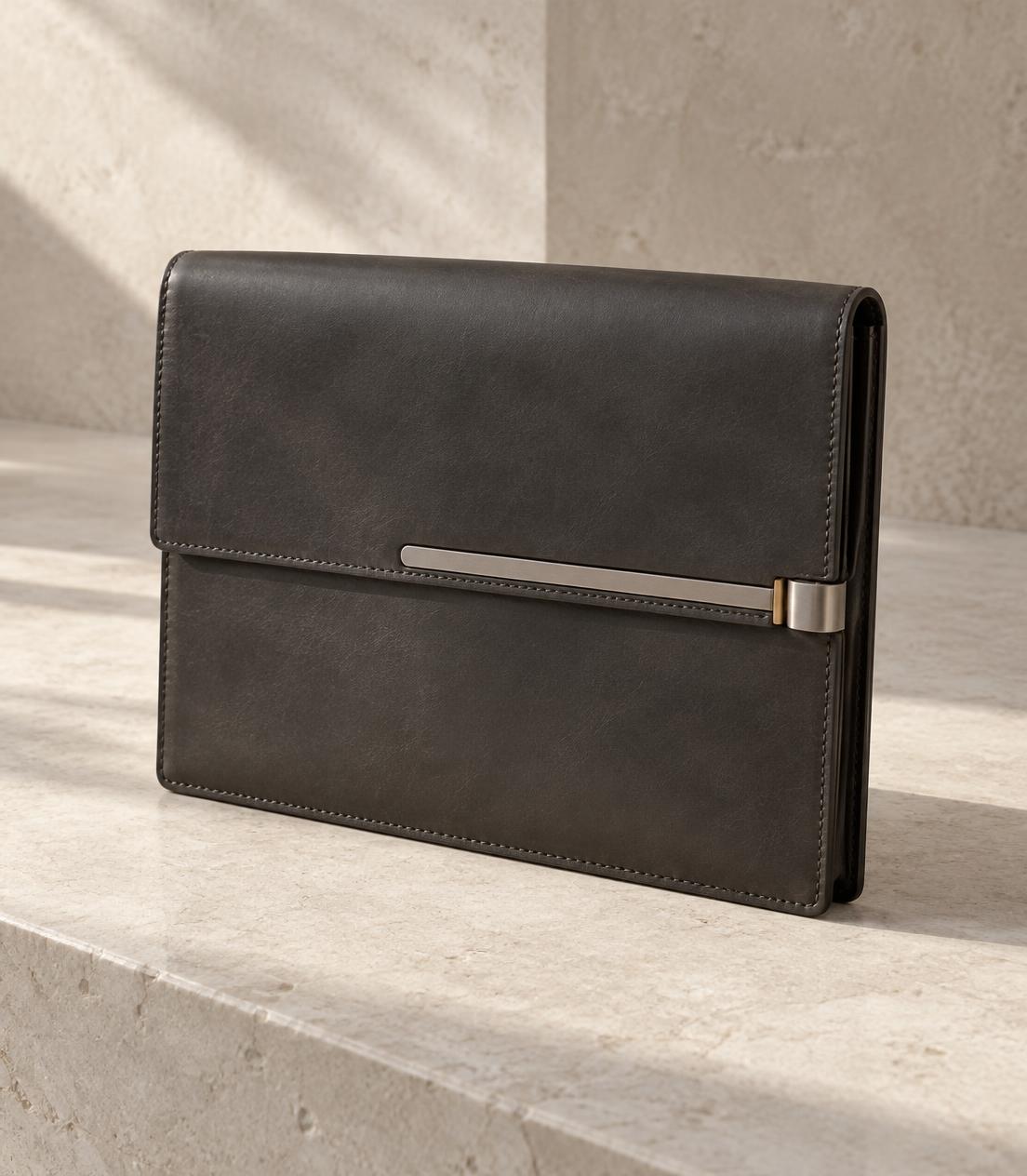 Concept study of a dark leather folio with an inset metal closure